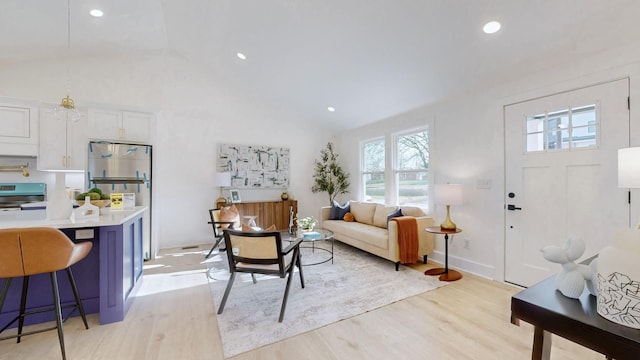 living room featuring light wood-style floors, recessed lighting, and high vaulted ceiling