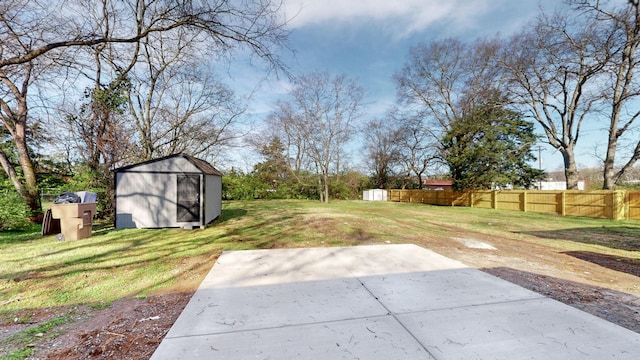 view of yard featuring an outdoor structure, a patio area, a shed, and fence
