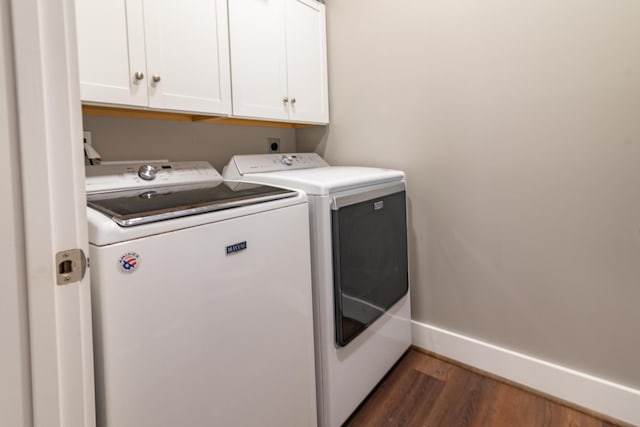laundry area featuring baseboards, cabinet space, washer and dryer, and dark wood-style floors