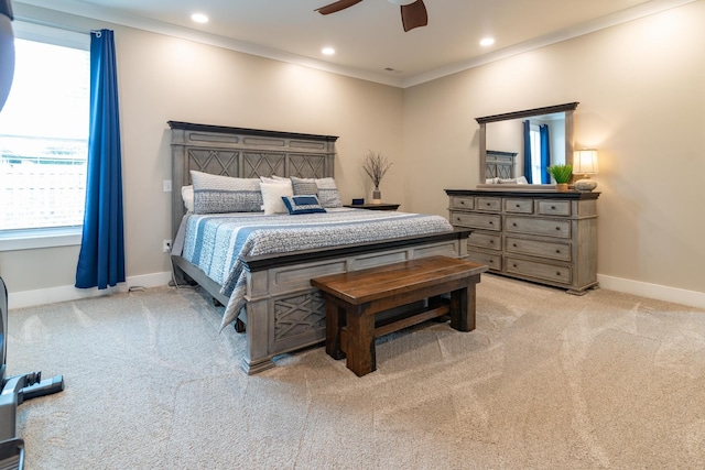 bedroom with crown molding, baseboards, multiple windows, and light carpet