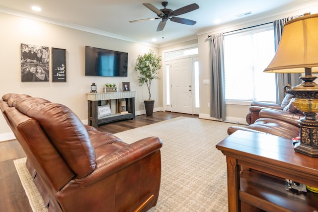 living room featuring baseboards, ceiling fan, visible vents, and wood finished floors