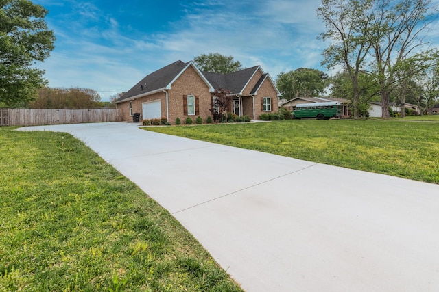 view of front of house featuring driveway, brick siding, fence, a front lawn, and an attached garage