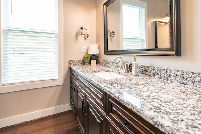 bathroom with baseboards, wood finished floors, and vanity