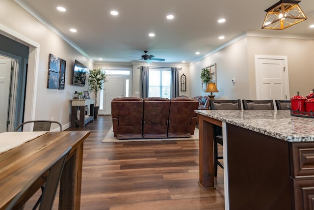 living area featuring crown molding, recessed lighting, ceiling fan, and dark wood finished floors