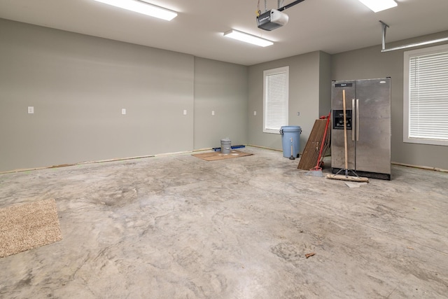garage featuring a garage door opener and stainless steel fridge with ice dispenser