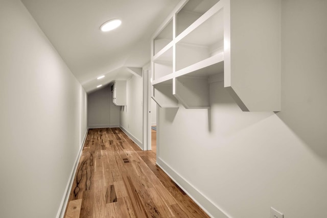 hallway featuring recessed lighting, baseboards, vaulted ceiling, and light wood finished floors