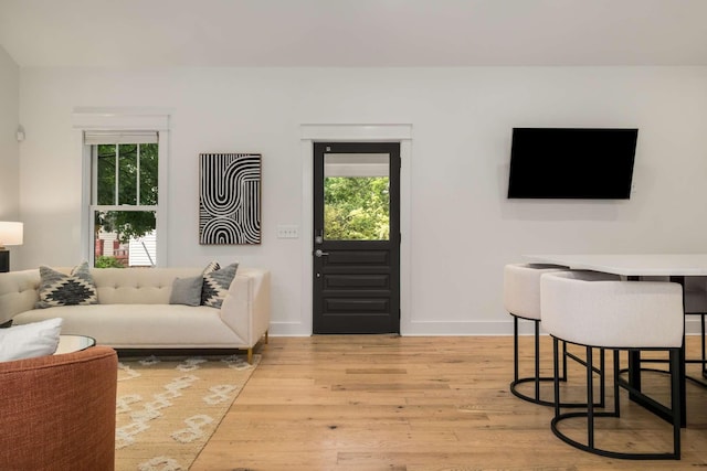 living room featuring baseboards and light wood-type flooring