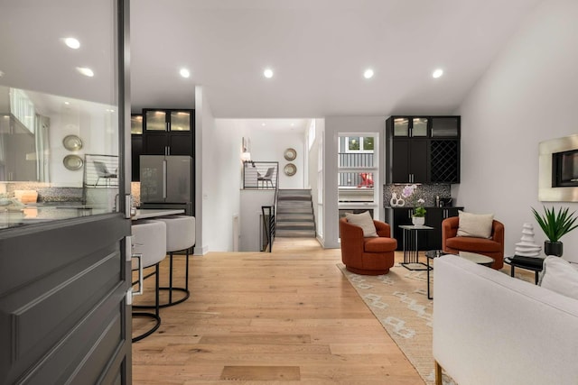 living area with light wood-type flooring, recessed lighting, and stairs