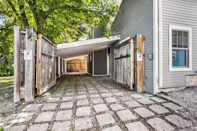 view of patio with fence and a carport