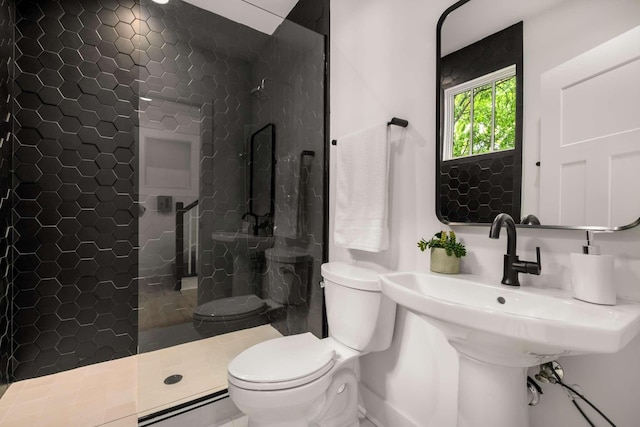 bathroom with a walk in shower, toilet, baseboards, and tile patterned flooring