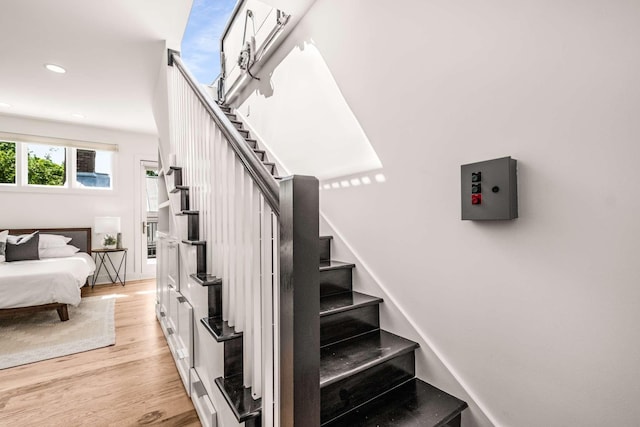 staircase with recessed lighting and wood finished floors
