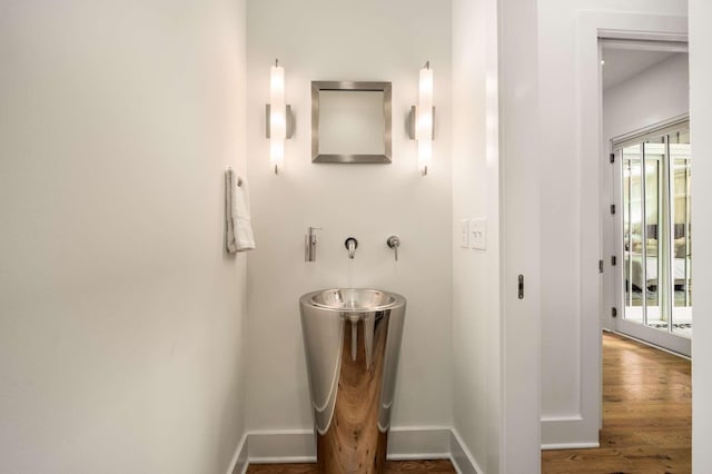 bathroom with baseboards and wood finished floors