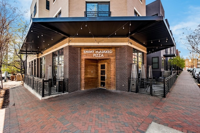 view of exterior entry with brick siding