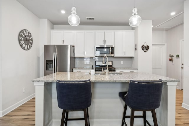 4326 Bomeadows Dr, Murfreesboro, TN 37128 - kitchen featuring appliances with stainless steel finishes, a sink, a breakfast bar area, light wood-style flooring, and visible vents