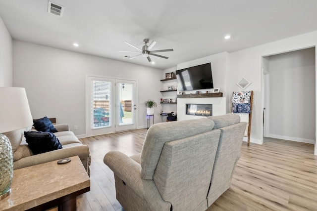 4326 Bomeadows Dr, Murfreesboro, TN 37128 - living area with light wood finished floors, a glass covered fireplace, a ceiling fan, baseboards, and visible vents