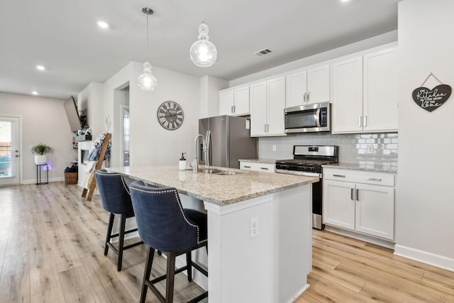 4326 Bomeadows Dr, Murfreesboro, TN 37128 - kitchen with light wood-style floors, appliances with stainless steel finishes, a breakfast bar, and an island with sink