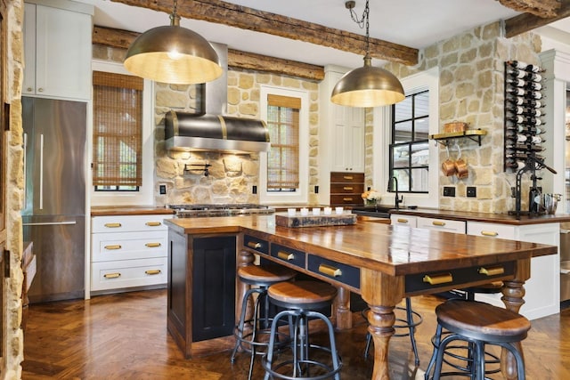 5715 Greenbrier Rd, Franklin, TN 37064 - bar featuring appliances with stainless steel finishes, hanging light fixtures, beam ceiling, a sink, and extractor fan