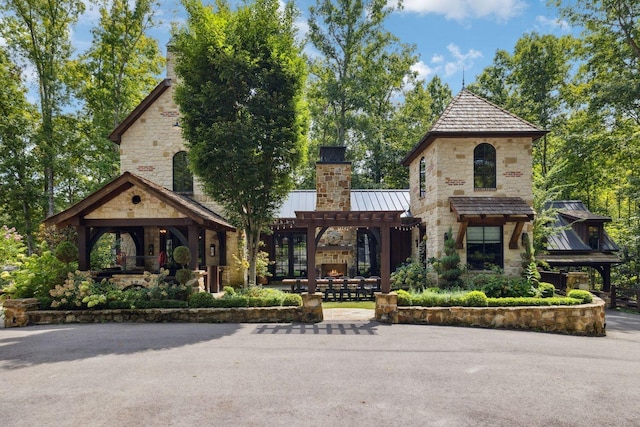 5715 Greenbrier Rd, Franklin, TN 37064 - view of front of home featuring a standing seam roof, a chimney, metal roof, a pergola, and stone siding