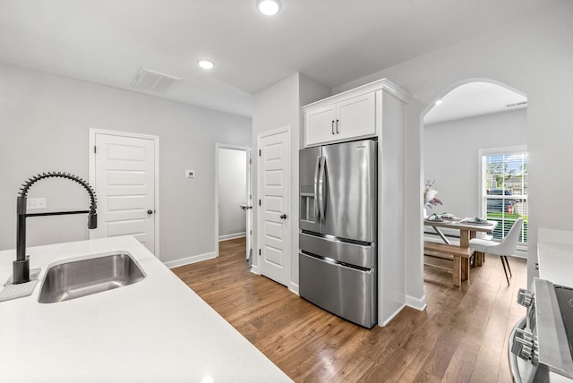 175 Harvard Dr, Gallatin, TN 37066 - kitchen featuring appliances with stainless steel finishes, a sink, arched walkways, white cabinetry, and wood finished floors