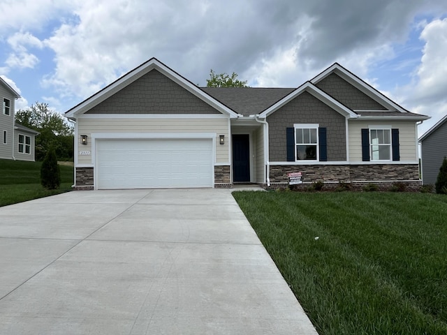 craftsman-style home with a front yard, driveway, stone siding, and a garage