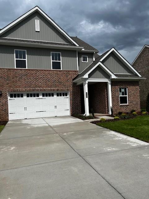craftsman house featuring concrete driveway, brick siding, and a garage