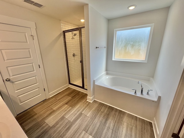 2626 Unitas Dr, Murfreesboro, TN 37129 - bathroom with a garden tub, a shower stall, and wood finished floors