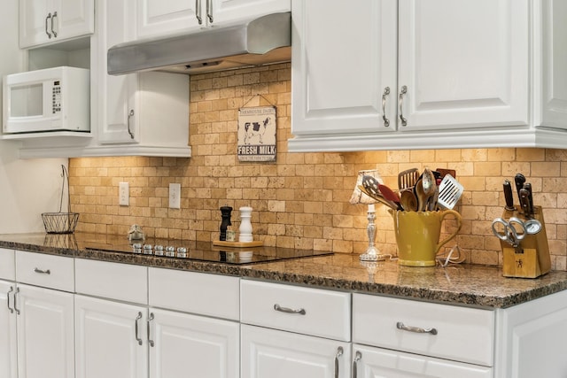 921 Cooks Rd, Mount Juliet, TN 37122 - kitchen featuring backsplash, white microwave, black electric stovetop, under cabinet range hood, and white cabinetry