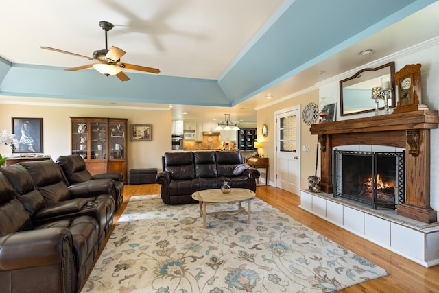 921 Cooks Rd, Mount Juliet, TN 37122 - living area with ornamental molding, light wood-type flooring, a tray ceiling, a tiled fireplace, and a ceiling fan