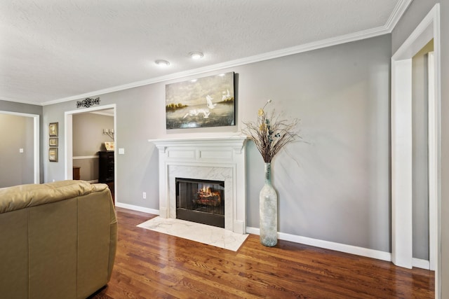 living room featuring ornamental molding, a premium fireplace, a textured ceiling, and dark wood-type flooring