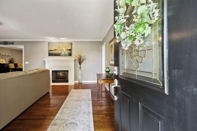 foyer entrance with baseboards, ornamental molding, a high end fireplace, and dark wood-type flooring