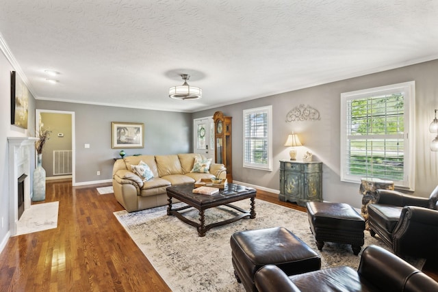 living room featuring crown molding, visible vents, plenty of natural light, and wood finished floors