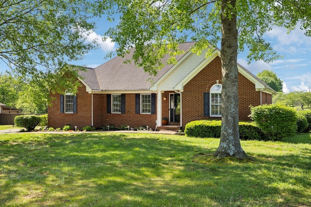 single story home with roof with shingles, a front lawn, and brick siding