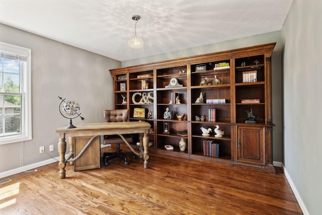 office space with baseboards, wood finished floors, and visible vents