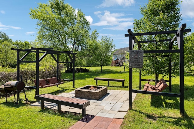 view of community featuring a lawn and an outdoor fire pit