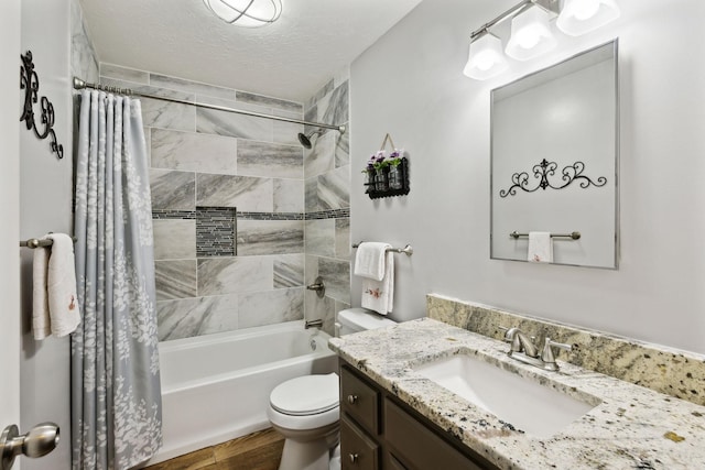 bathroom featuring vanity, toilet, a textured ceiling, wood finished floors, and shower / tub combo