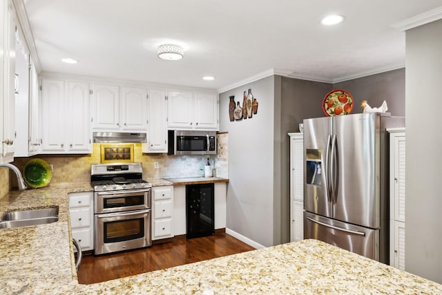 kitchen with appliances with stainless steel finishes, a sink, beverage cooler, dark wood-type flooring, and under cabinet range hood