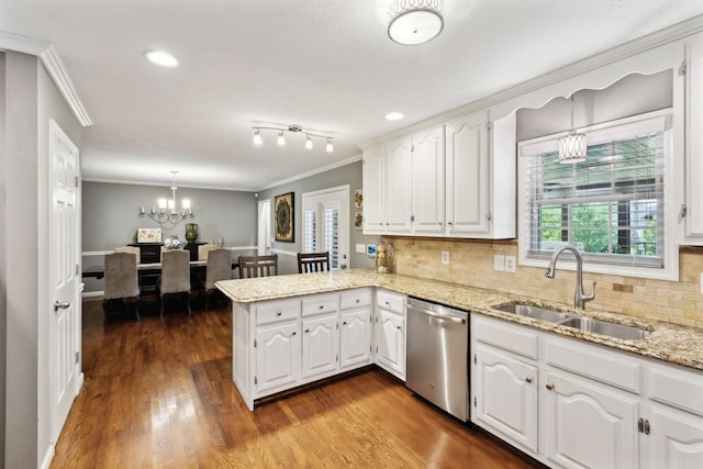 kitchen featuring an inviting chandelier, a sink, a peninsula, stainless steel dishwasher, and ornamental molding