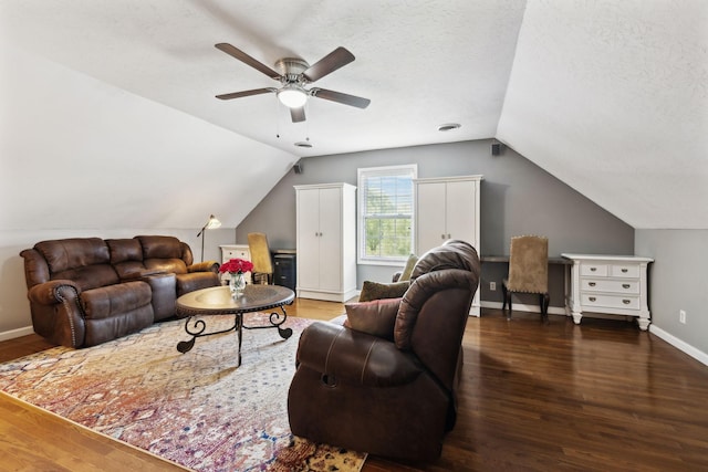 living area with ceiling fan, a textured ceiling, baseboards, wood finished floors, and vaulted ceiling