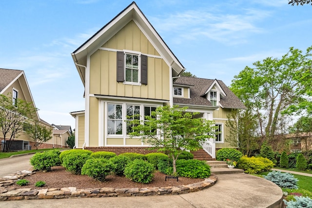 craftsman-style home with board and batten siding, brick siding, and roof with shingles