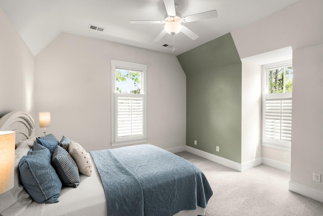 carpeted bedroom featuring baseboards, a ceiling fan, vaulted ceiling, and visible vents