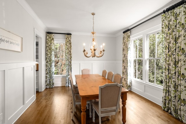 dining area with an inviting chandelier, a decorative wall, and a healthy amount of sunlight
