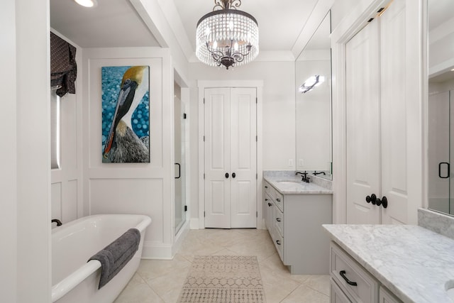 bathroom with a freestanding bath, an inviting chandelier, vanity, a shower stall, and a closet
