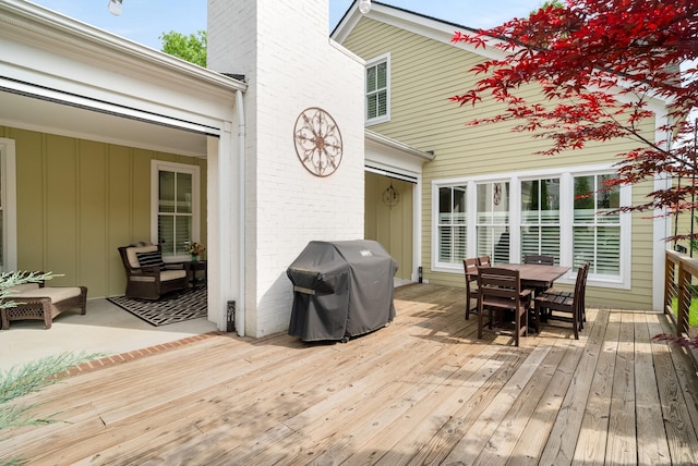 deck featuring outdoor dining space and grilling area