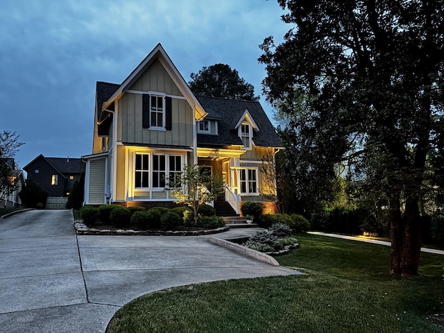 craftsman inspired home with board and batten siding, driveway, and a front yard