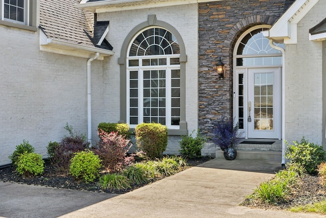 view of exterior entry with brick siding and stone siding