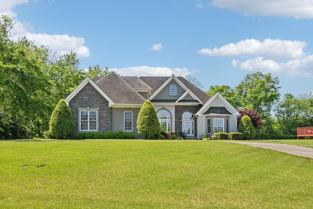 view of front of home featuring stone siding, a front yard, and stucco siding