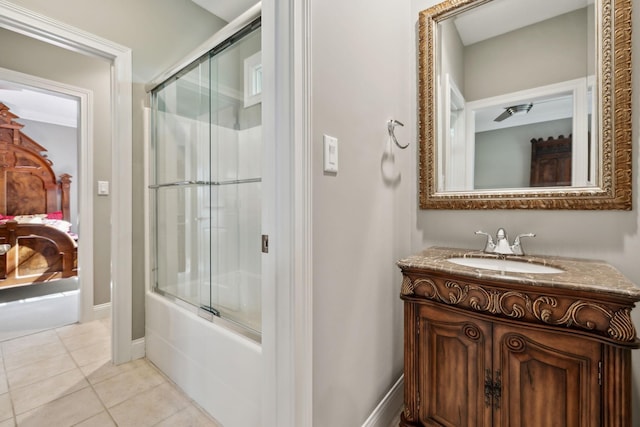 full bathroom featuring tile patterned flooring, vanity, baseboards, ensuite bathroom, and bath / shower combo with glass door