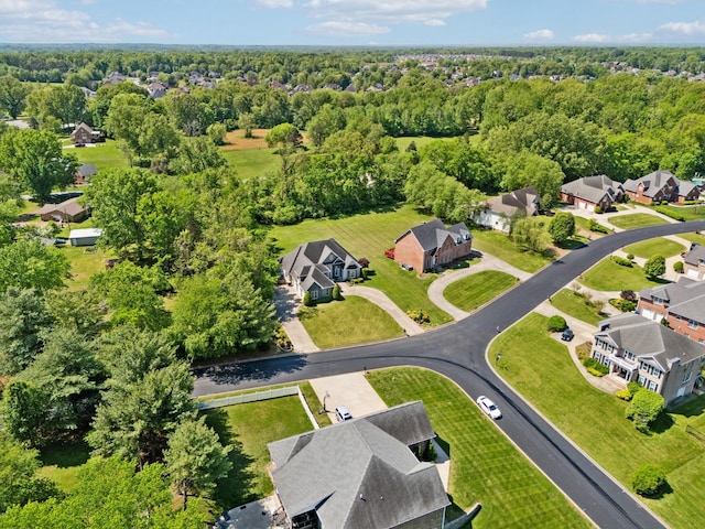 drone / aerial view featuring a forest view and a residential view