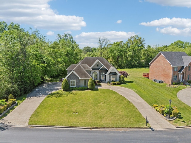 view of front facade featuring concrete driveway and a front lawn
