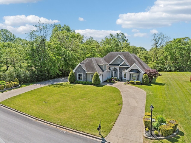 craftsman inspired home featuring a garage, a front yard, and concrete driveway